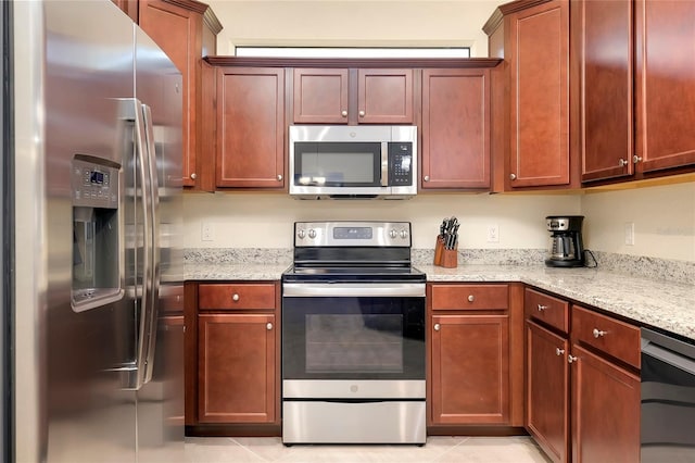 kitchen with light stone counters, light tile patterned floors, and appliances with stainless steel finishes