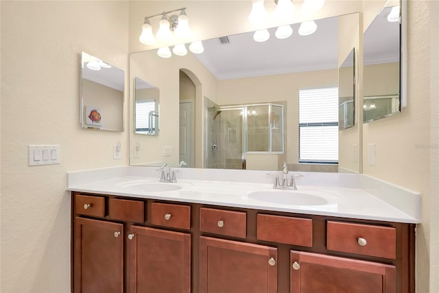 bathroom with vanity, a shower with shower door, and ornamental molding