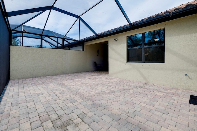 view of patio featuring a lanai