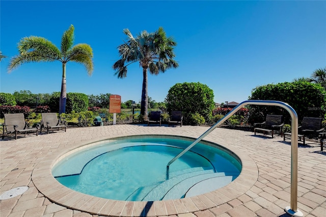 view of swimming pool with a patio area and a hot tub