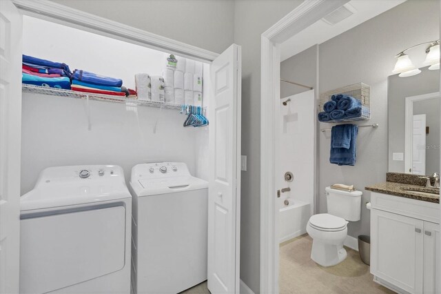 laundry area featuring sink, light tile patterned flooring, and washer and clothes dryer