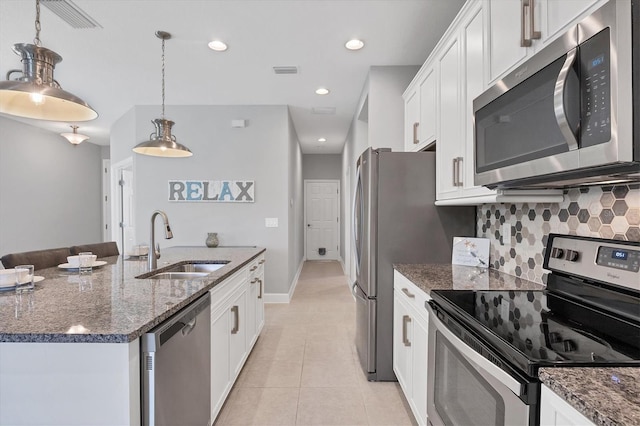 kitchen featuring appliances with stainless steel finishes, sink, pendant lighting, and white cabinets