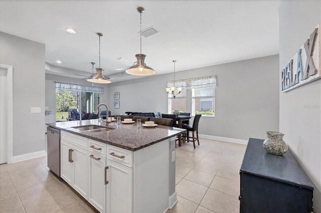 kitchen featuring a center island with sink, sink, stainless steel dishwasher, a healthy amount of sunlight, and white cabinets