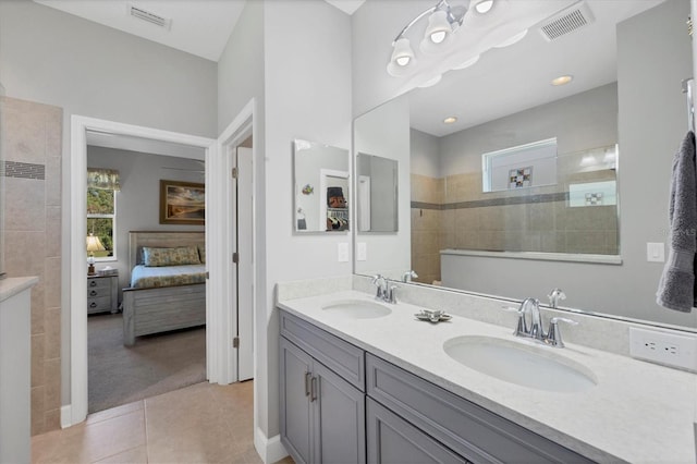 bathroom with tile patterned floors, tiled shower, and vanity