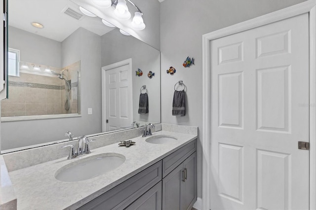 bathroom with vanity and tiled shower