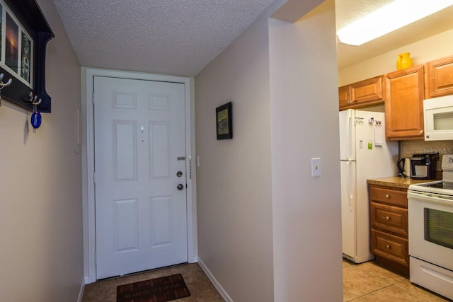 doorway featuring light tile patterned floors and a textured ceiling