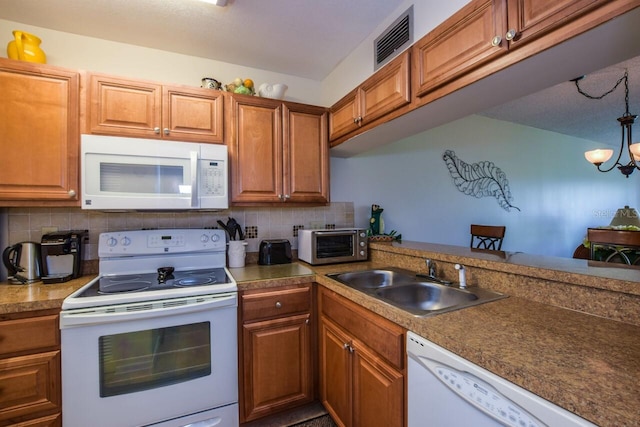 kitchen with a chandelier, white appliances, sink, and tasteful backsplash