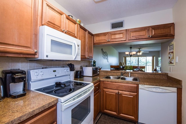 kitchen featuring decorative backsplash, sink, ceiling fan with notable chandelier, and white appliances