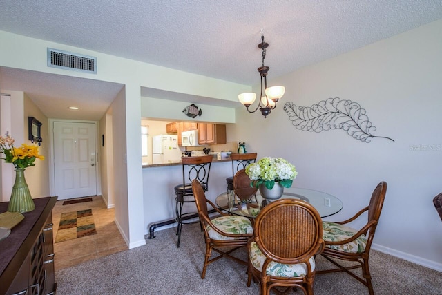 dining space featuring carpet flooring, a textured ceiling, and a chandelier