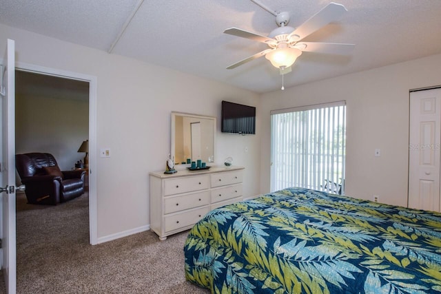 carpeted bedroom with ceiling fan and a textured ceiling