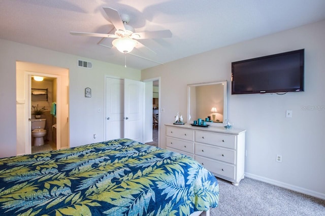 bedroom with a closet, light colored carpet, ensuite bath, and ceiling fan