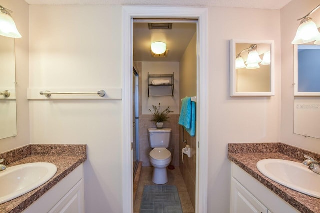 bathroom with tile walls, vanity, a textured ceiling, and toilet