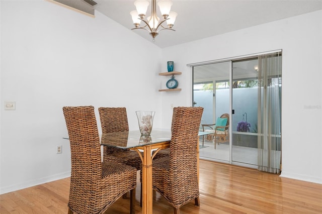 dining area featuring light hardwood / wood-style floors and an inviting chandelier