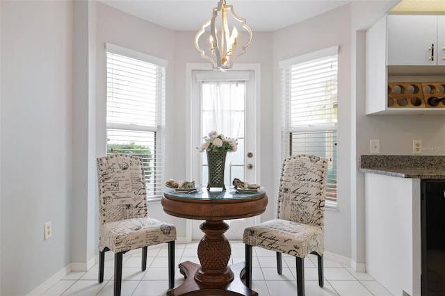 living area with a chandelier, light tile patterned floors, and plenty of natural light