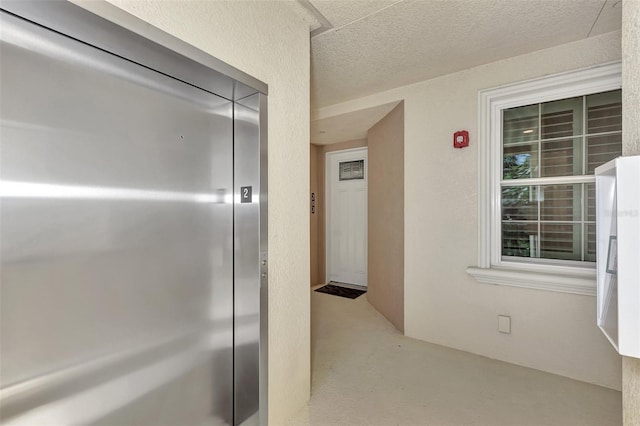 interior space featuring a textured ceiling and elevator