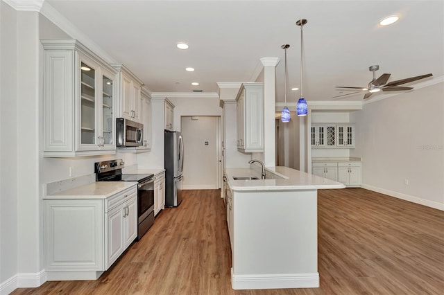 kitchen with ceiling fan, decorative light fixtures, light hardwood / wood-style floors, and appliances with stainless steel finishes