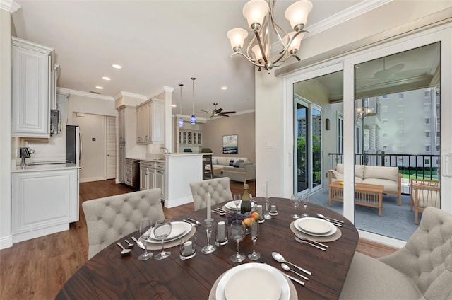 dining space with ceiling fan with notable chandelier, dark hardwood / wood-style flooring, ornamental molding, and sink