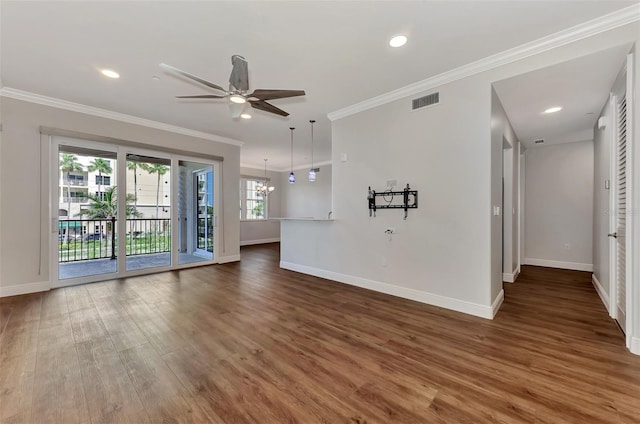 unfurnished living room with ceiling fan with notable chandelier, dark hardwood / wood-style floors, and ornamental molding