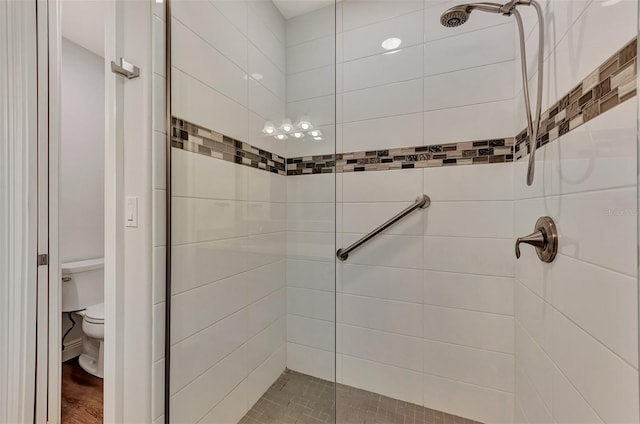 bathroom featuring a tile shower and toilet