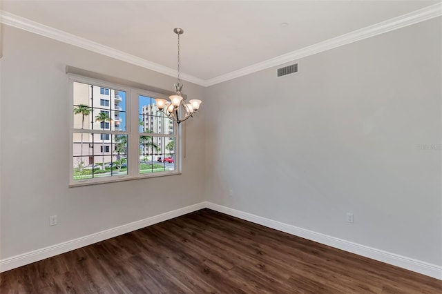 empty room featuring dark hardwood / wood-style flooring, ornamental molding, and a chandelier