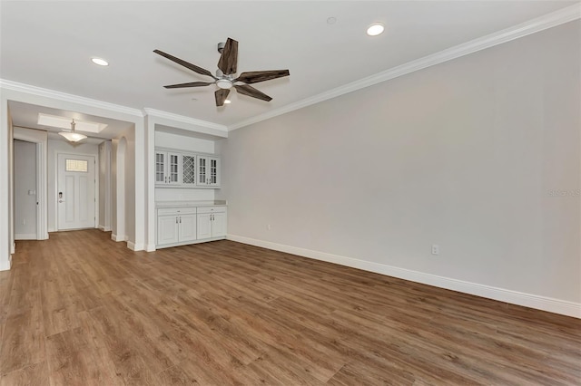 unfurnished living room with crown molding, hardwood / wood-style floors, and ceiling fan