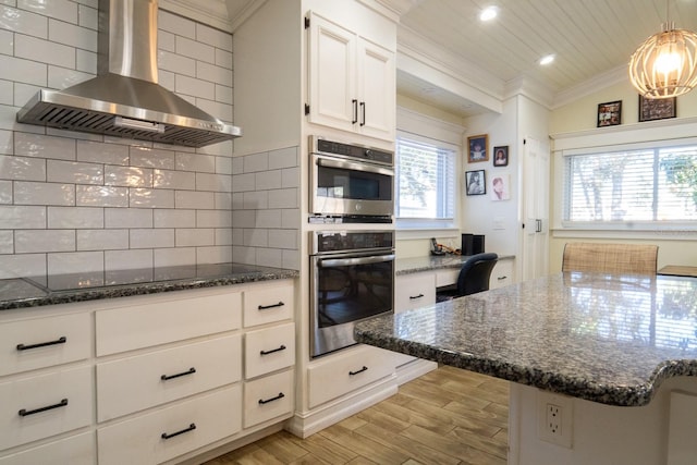 kitchen featuring lofted ceiling, wall chimney exhaust hood, white cabinetry, black electric cooktop, and decorative backsplash