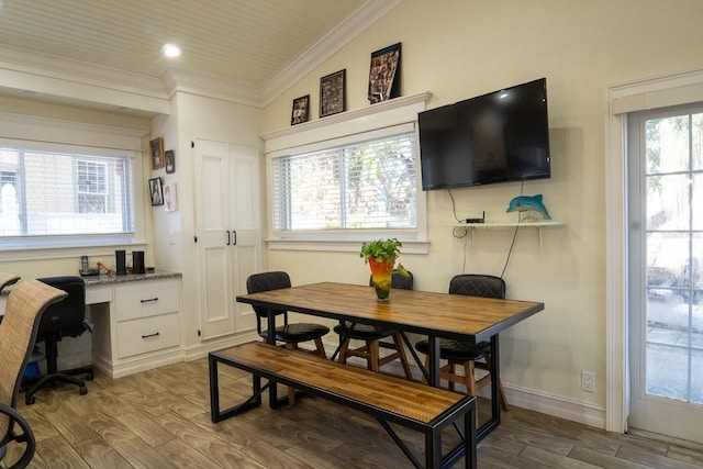 dining space with ornamental molding, built in desk, and vaulted ceiling