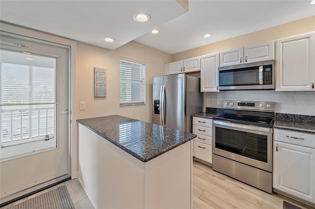 kitchen with appliances with stainless steel finishes, white cabinetry, and a wealth of natural light