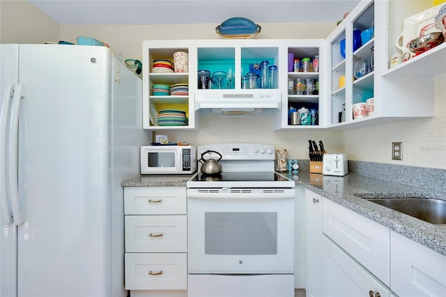 kitchen with white cabinets, light stone countertops, white appliances, and tasteful backsplash