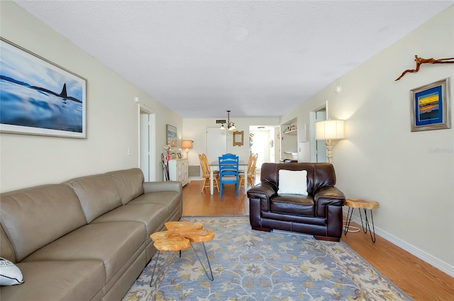 living room with hardwood / wood-style floors, a textured ceiling, and a chandelier