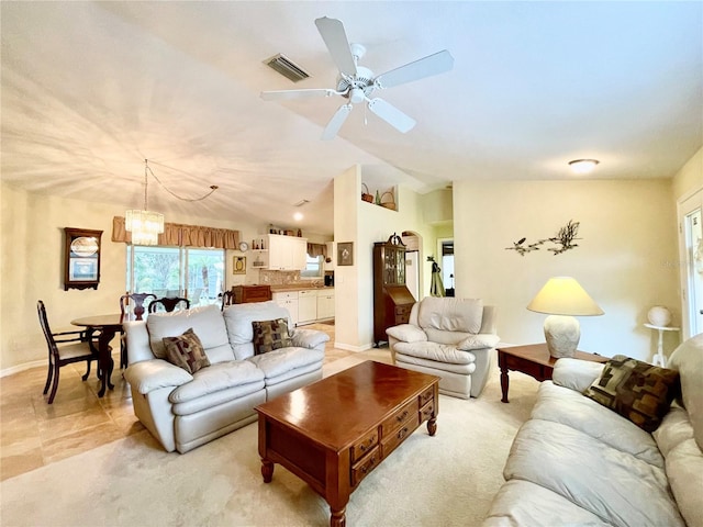 living room with ceiling fan with notable chandelier, lofted ceiling, and light tile patterned floors