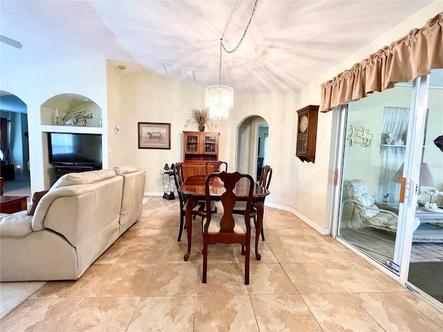 dining space featuring vaulted ceiling and an inviting chandelier