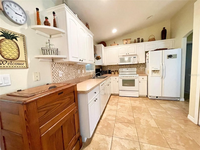 kitchen featuring decorative backsplash, white appliances, vaulted ceiling, white cabinets, and light tile patterned flooring