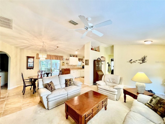 living room with ceiling fan with notable chandelier and lofted ceiling