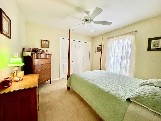 bedroom featuring ceiling fan, a closet, and light carpet