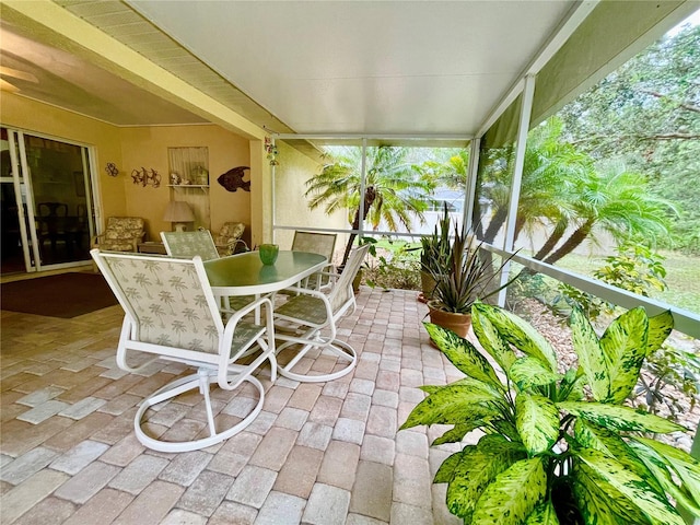 unfurnished sunroom with ceiling fan