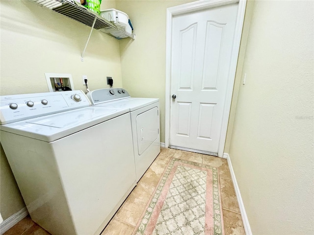 laundry area featuring washing machine and dryer and light tile patterned floors