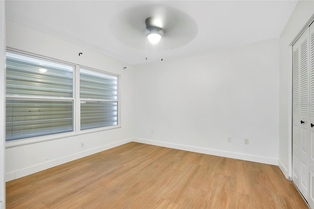 unfurnished bedroom featuring light wood-type flooring, ceiling fan, and a closet