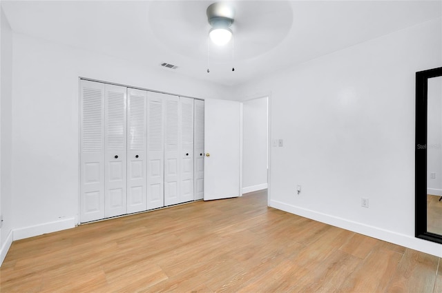 unfurnished bedroom with ceiling fan, a closet, and light hardwood / wood-style flooring