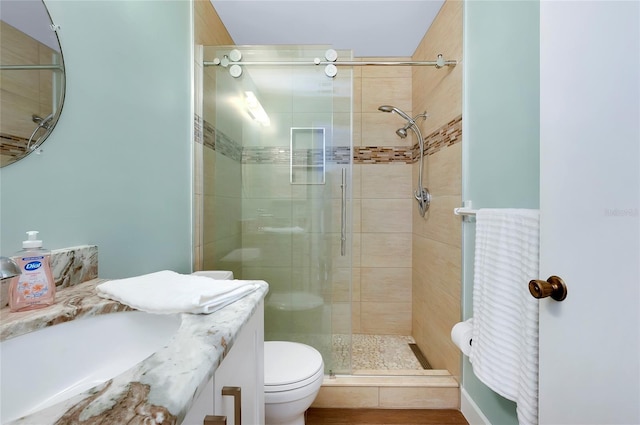 bathroom with a shower with shower door, toilet, and vanity