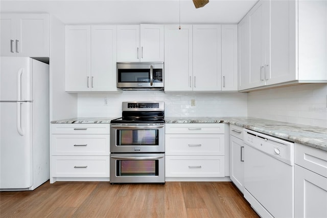 kitchen with tasteful backsplash, light hardwood / wood-style floors, stainless steel appliances, and white cabinetry