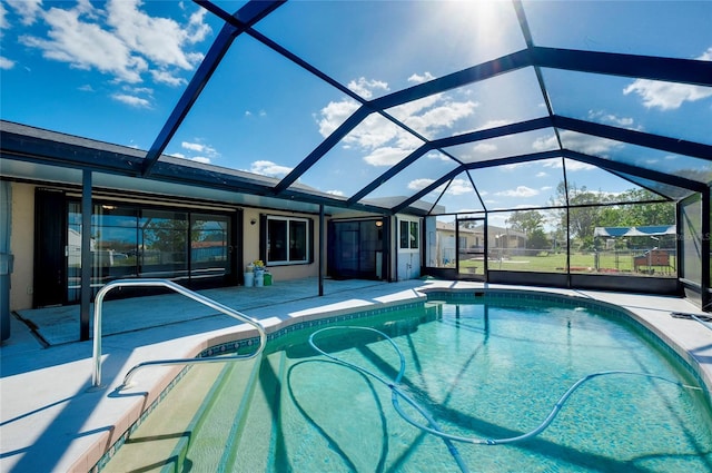 view of pool featuring glass enclosure and a patio area