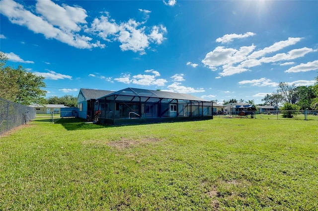 back of property featuring glass enclosure and a yard