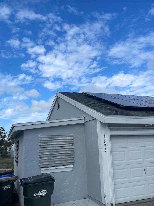 exterior space with solar panels and a garage