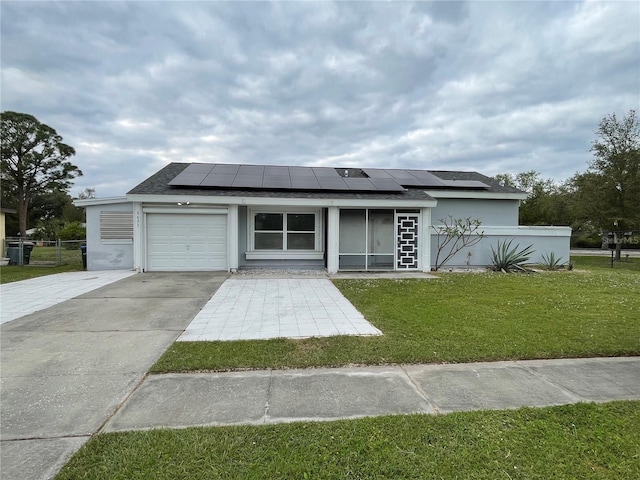 view of front facade with a front lawn, solar panels, and a garage