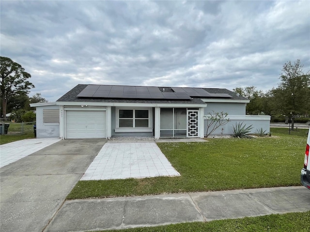 view of front of property with a front lawn, solar panels, and a garage