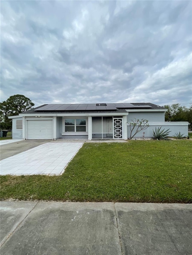 view of front of home with a front yard and a garage