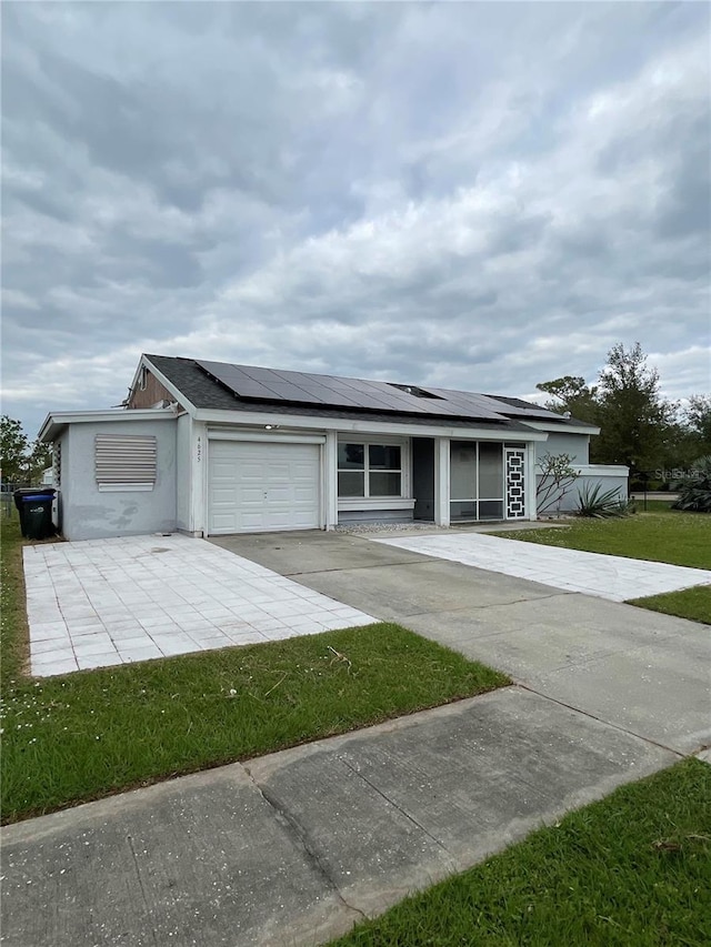 ranch-style house featuring a garage and solar panels