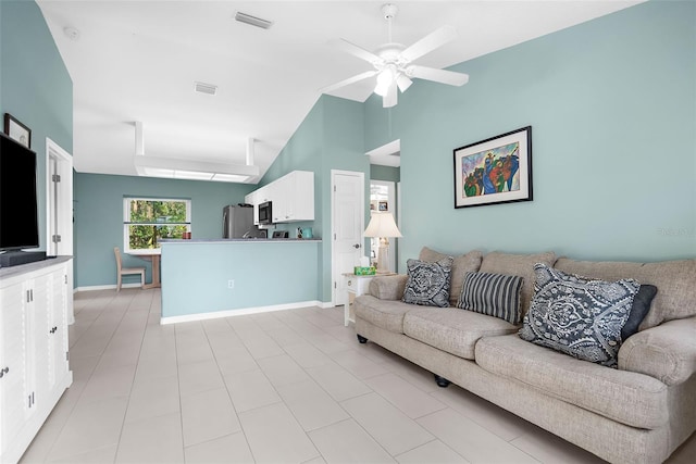 living room featuring ceiling fan and a towering ceiling