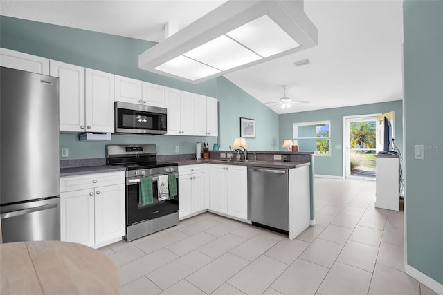 kitchen with kitchen peninsula, appliances with stainless steel finishes, ceiling fan, white cabinetry, and lofted ceiling